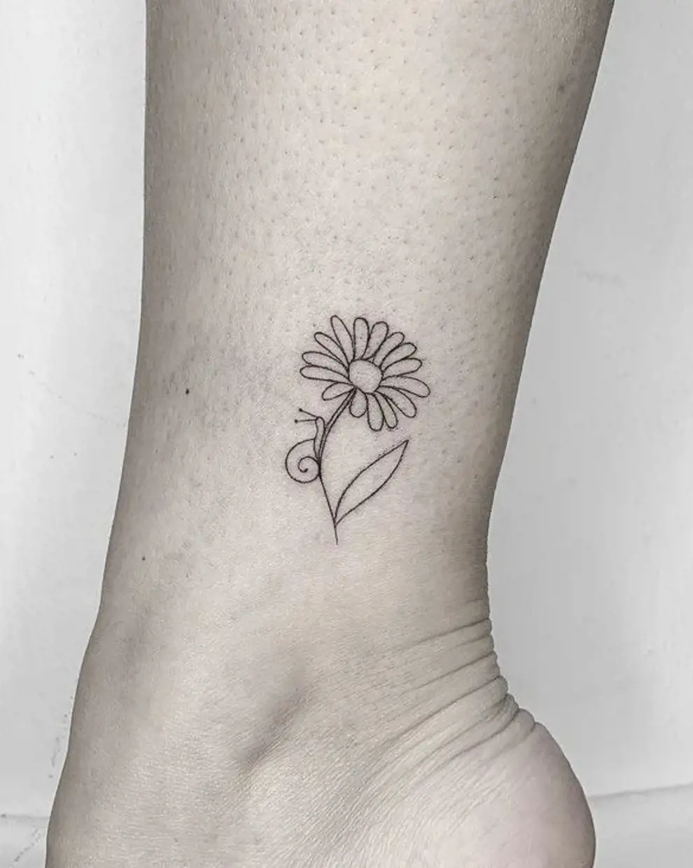 Tatuajes minimalistas mujer: flor y caracol