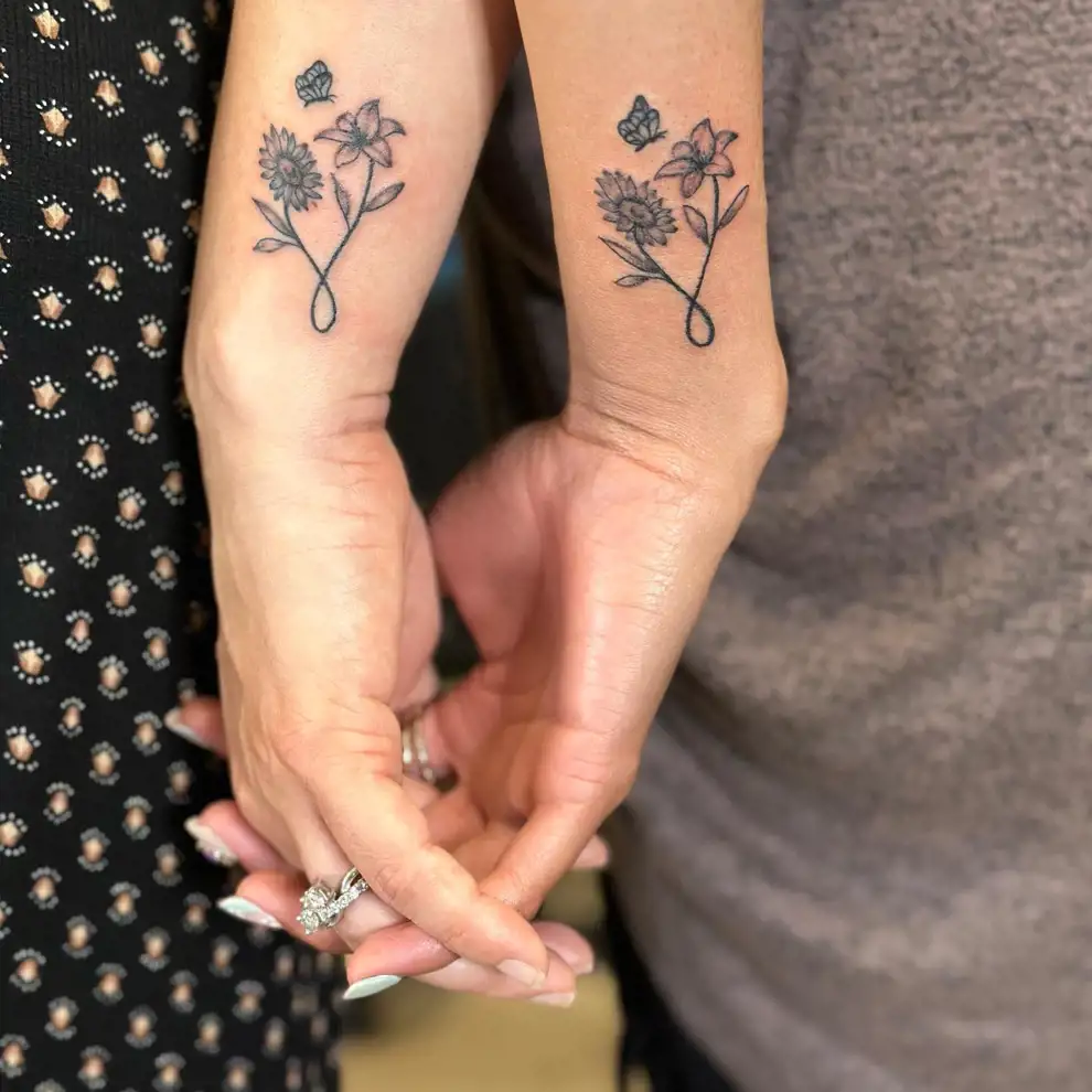 Tatuajes madre e hija: abrazo con flores diferentes